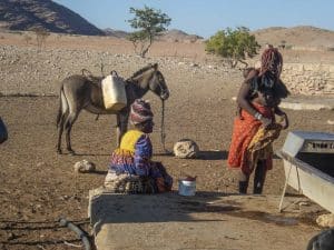 Hereros und Himbas am Brunnen
